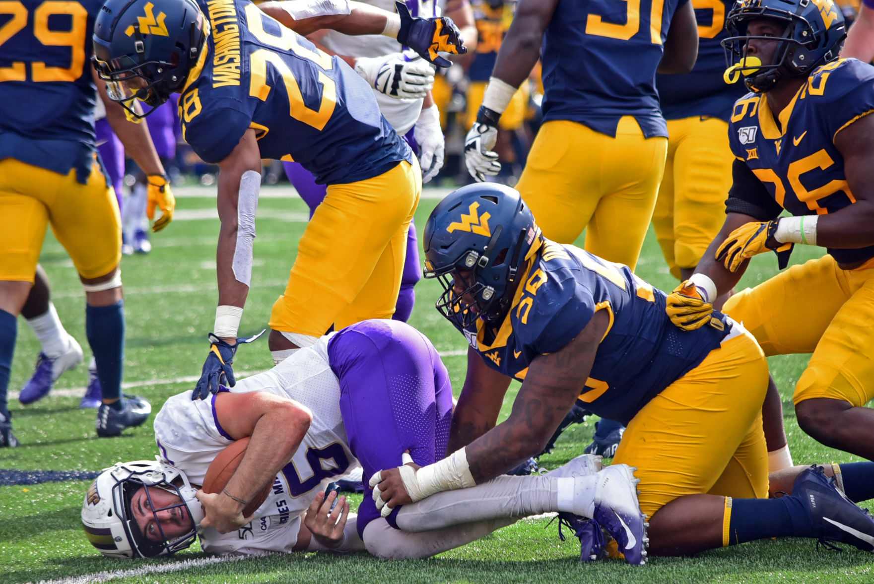 West Virginia linebacker Jared Bartlett tackles James Madison quarterback Ben DiNucci.